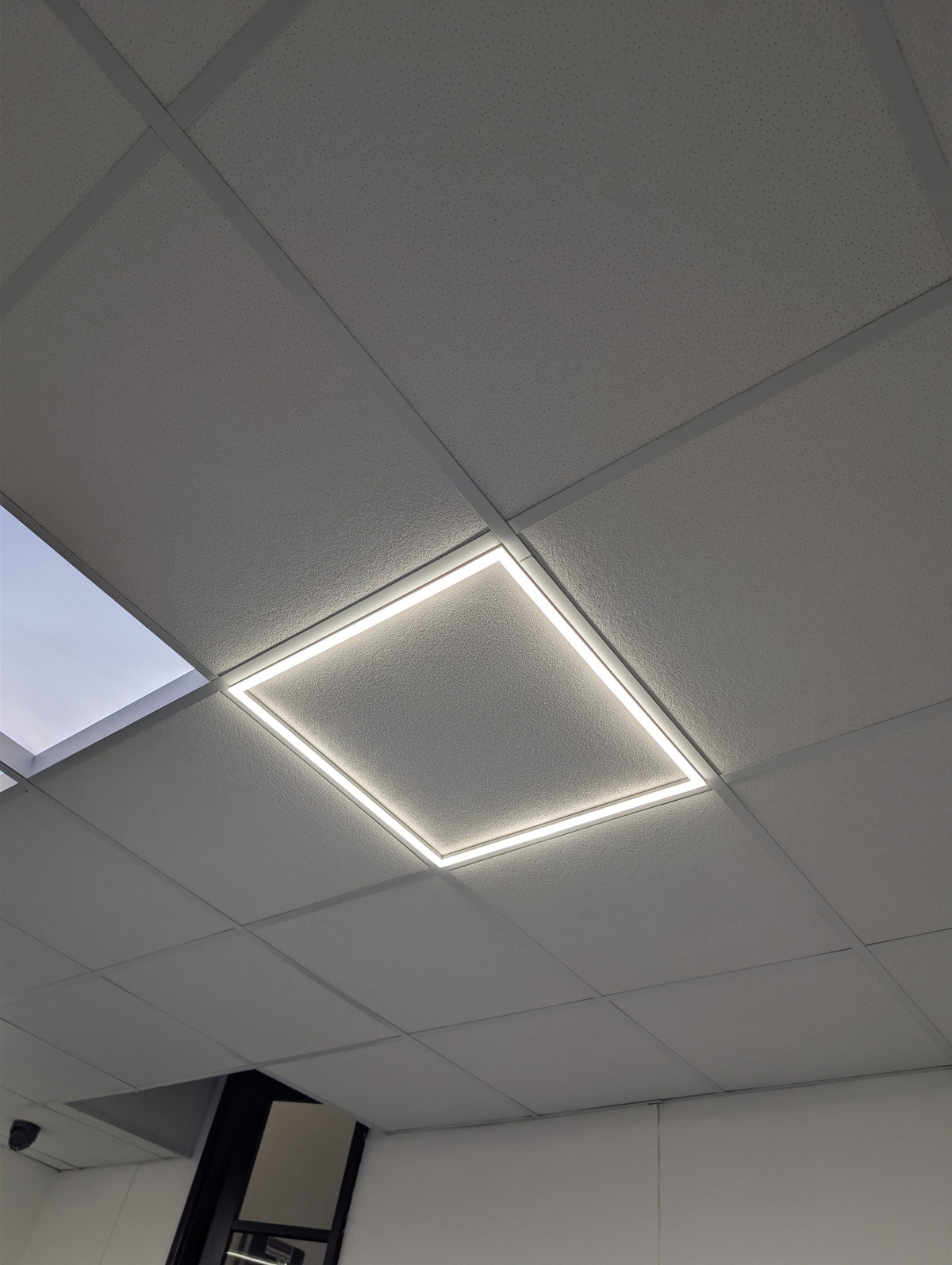 Linear frame light installed and lit in a real suspended ceiling