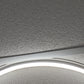 Close-up detail of the lit Round Halo ring, aluminium frame edge and ceiling tile texture