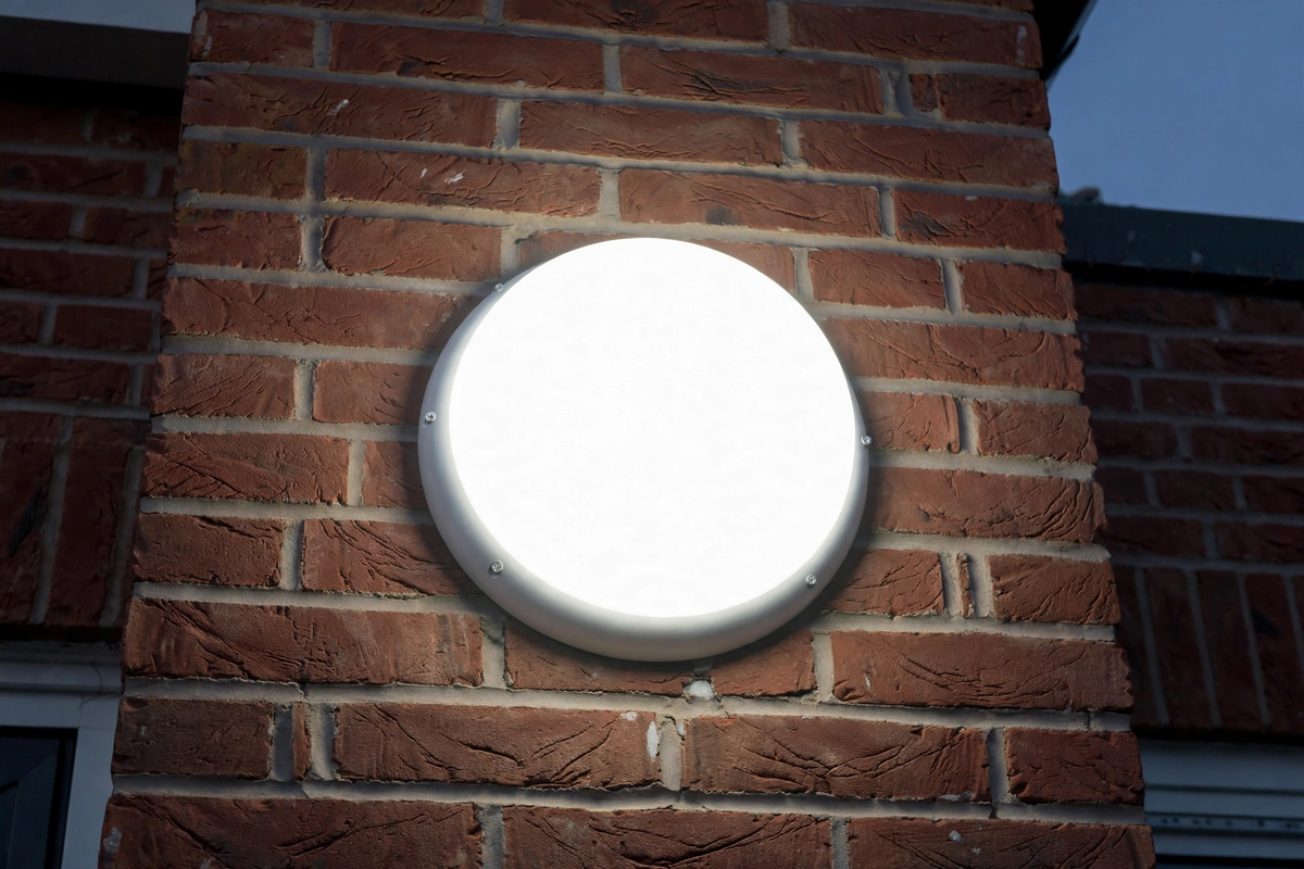 AIO bulkhead installed on exterior brick wall at dusk, lit