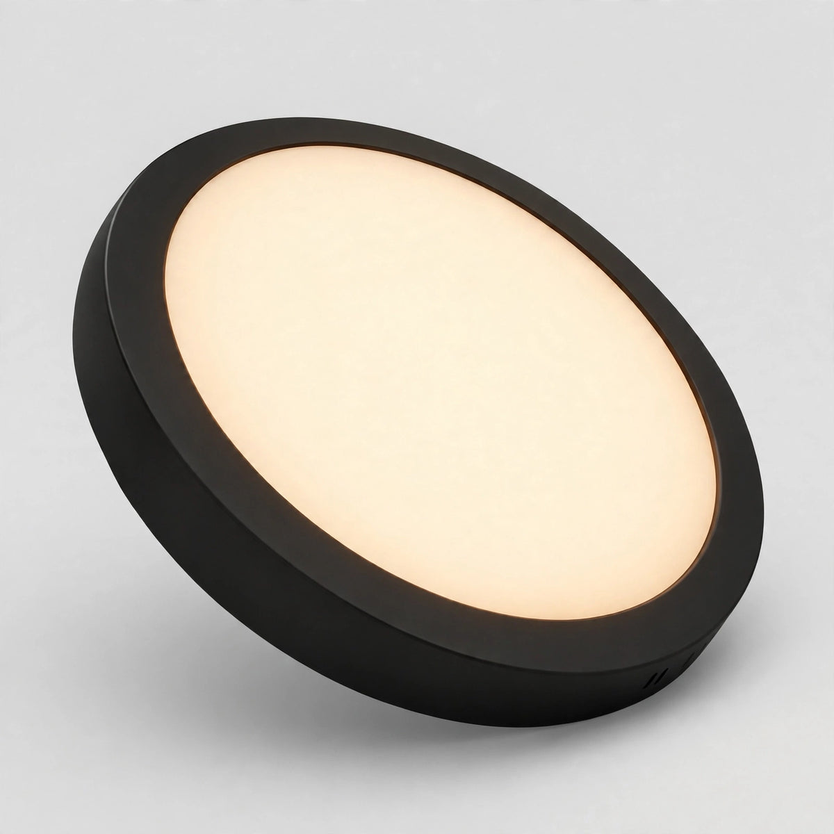 Black round LED panel light glowing in 3000K warm white
